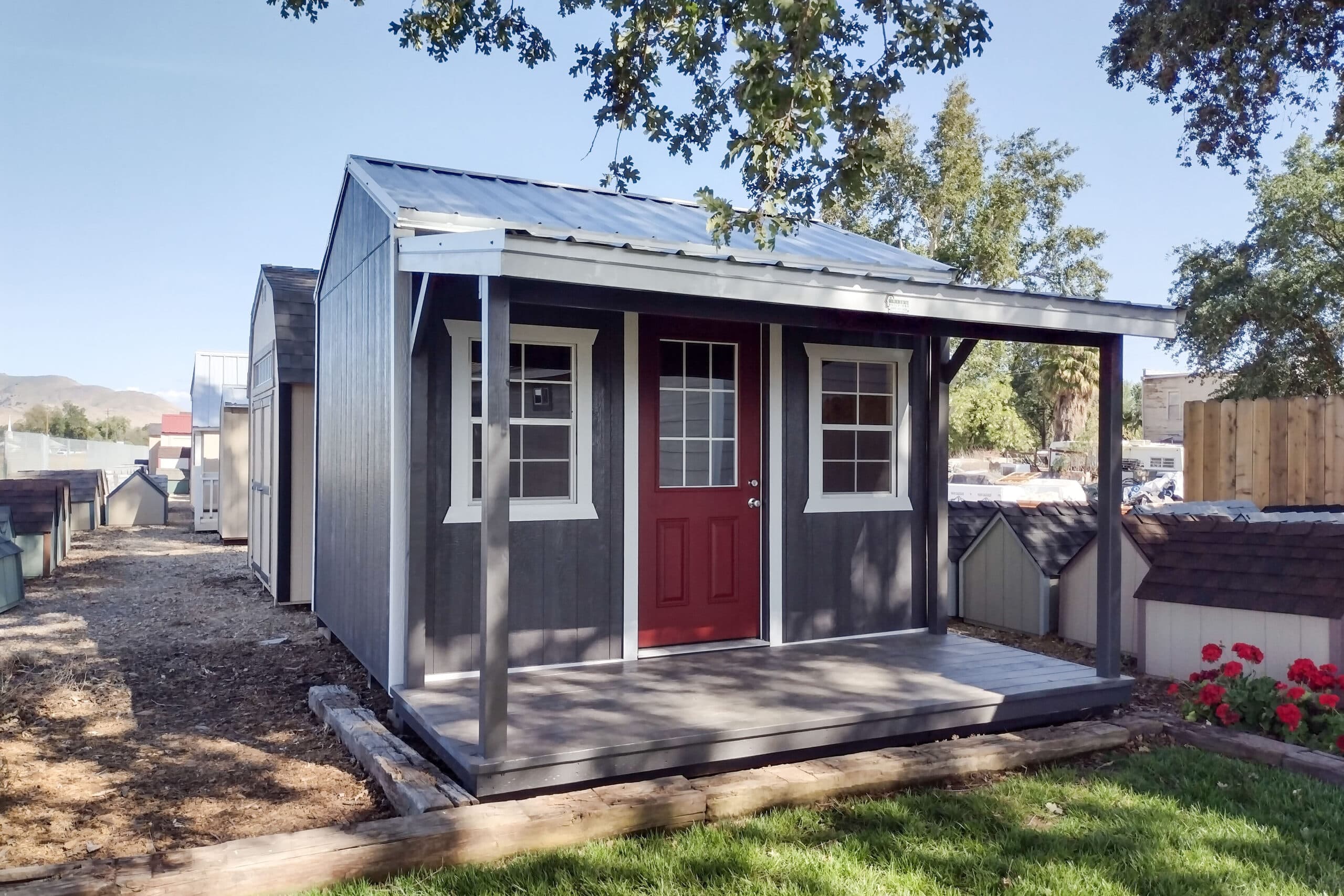 blue and white trimmed shed with red front door and front porch built according to shed permits in California requirements