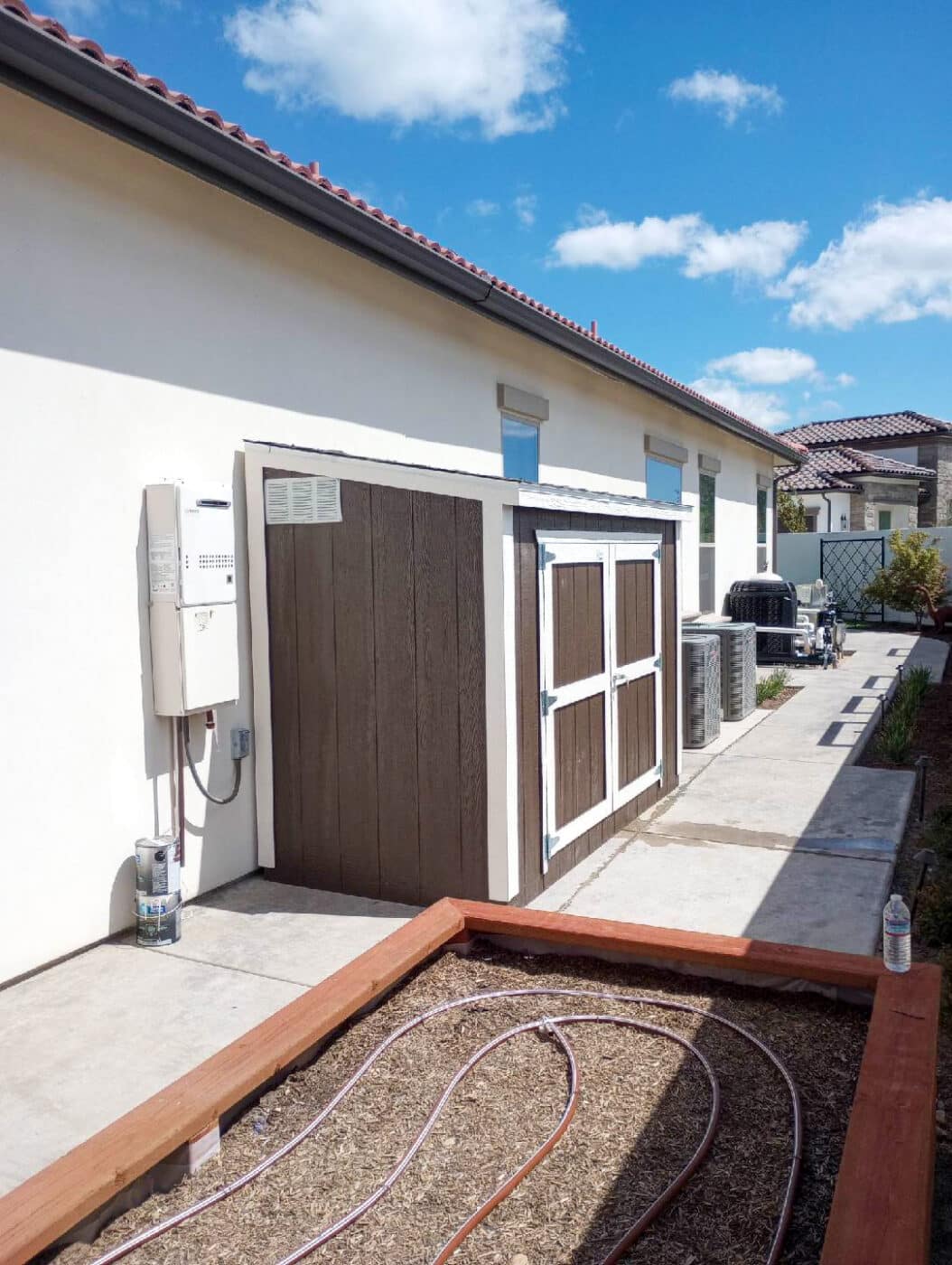 brown lean to shed next to home with white trim in Oakhurst CA