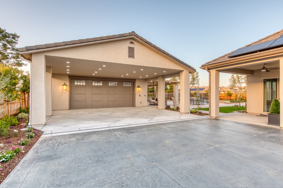 tan garage with overhang and brown overhead door