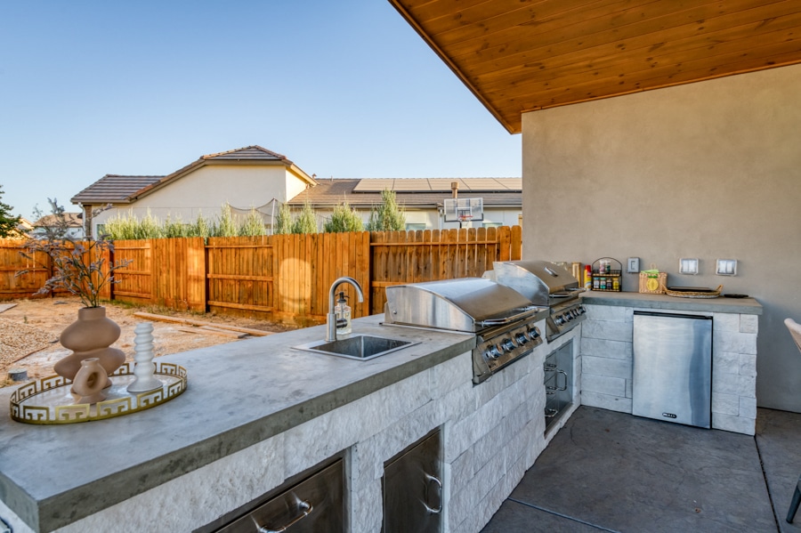 modern kitchen with grill and fridge under tan pavilion in Auberry, CA