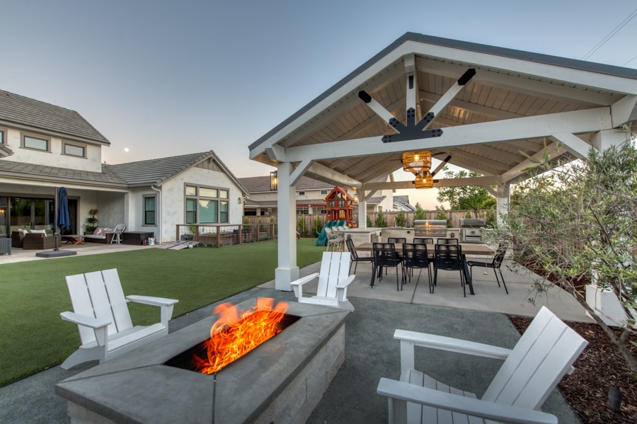outdoor pavilion with seating area by fire pit lit during evening