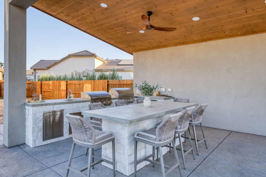 seating area underneath pavilion with outdoor kitchen area