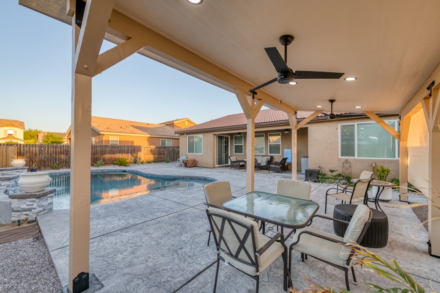 seating area with fans under tan pavilion by pool in aUberry, CA