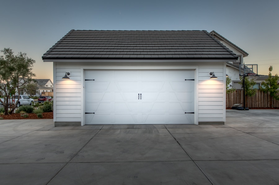 white one car garage with lights on at night